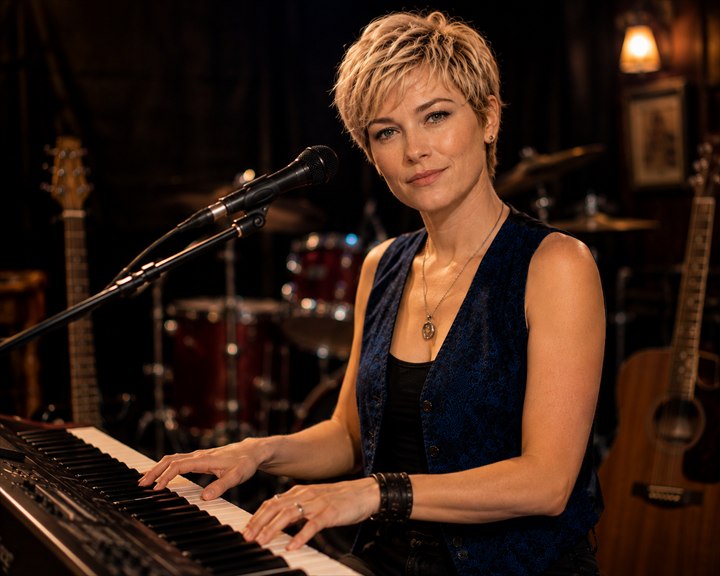 Aileen Flynn singing while playing keyboards during a live performance